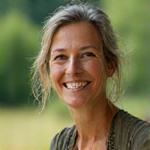 Mona Lisa-like portrait of Betty S Miller, the perfumer, smiling warmly in a natural, earthy setting.