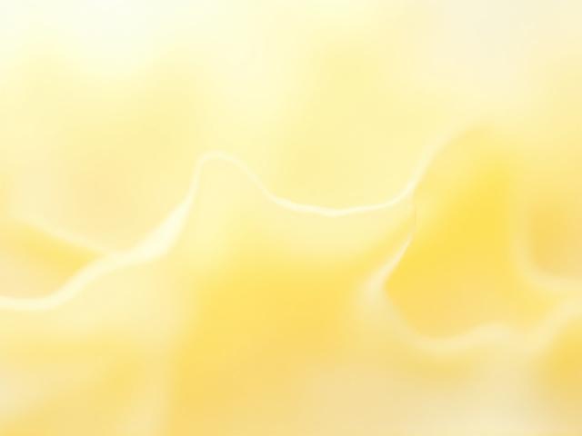 Macro shot of light yellow candelilla wax flakes, appearing delicate and light.